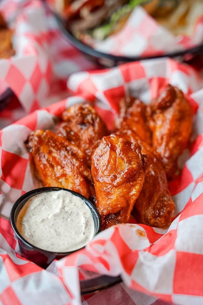 close-up of chicken wings covered in sauce served with ranch